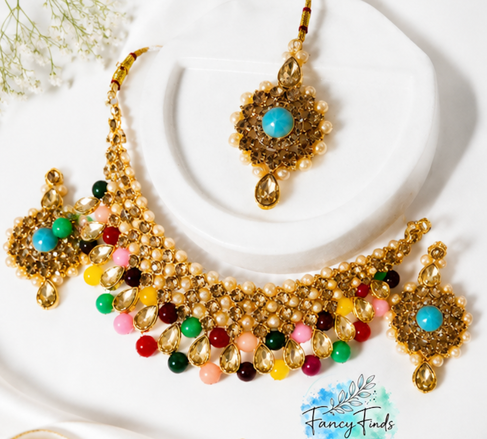 Colorful beaded necklace with gold accents on a white background, featuring the brand 'Fancy Finds'.