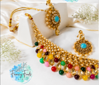 Gold necklace with colorful beads and matching earrings on a white fabric background, branded 'Fancy Finds'.